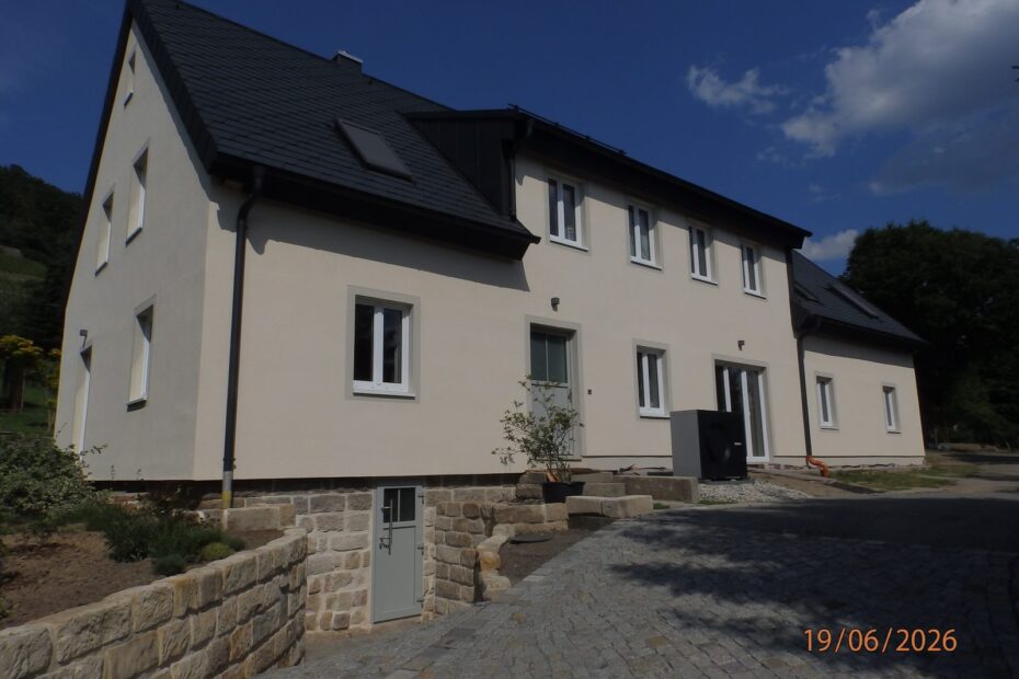 Fertig saniertes Wohnhaus der Bauherrengemeinschaft in Dresden-Pillnitz mit Sandsteinsockel und gepflasterter Zufahrt